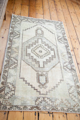 Hand-knotted vintage Oushak rug corner with faded celadon and brown geometric border.