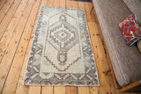 Subtle geometric Oushak design with faded celadon, platinum, and ivory tones.