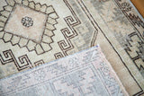 Close-up of the vintage Oushak rug's muted geometric pattern and hand-knotted foundation.