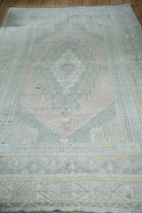 Central geometric medallion of vintage Oushak rug in peach, grey, and ivory.