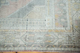 Vintage Oushak rug features geometric border patterns in peach, grey, and pale ivory.