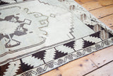Hand-knotted vintage Oushak rug's charcoal and ivory geometric border.
