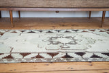 Vintage Oushak rug with charcoal and blanched ivory geometric border motif.