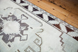 Vintage Oushak rug corner with minimalist geometric border in blanched ivory and charcoal.