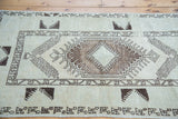 Textural distressed charcoal and ivory geometric pattern on a vintage Turkish Oushak rug.