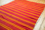 Soft flat-weave wool texture and vibrant orange and yellow stripes of the Kilim.