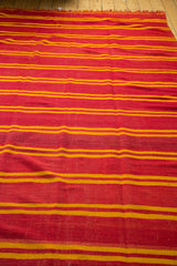 Soft wool texture and bold orange and yellow stripes of the vintage Kilim rug.