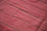 Detail of soft cranberry red vintage Moroccan Kilim weave with dark thin stripes.