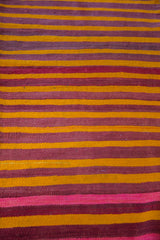 Soft wool texture of eggplant purple, fire orange, and bright pink striped vintage kilim.