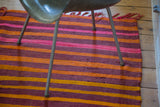 Textured wool stripes in eggplant purple, fire orange, and bright pink with fringe.