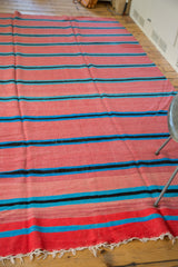 White fringe and striped pattern of pink, blue, black vintage Moroccan kilim.
