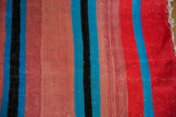 Soft flatweave detail of Moroccan kilim, showing vivid pink, blue, black, and red stripes.