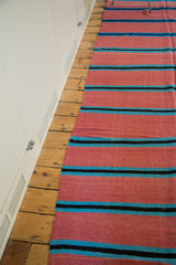 Soft wool texture of the Moroccan kilim, with pink, bright blue, and black stripes.
