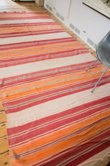 Soft wool vintage Moroccan Kilim runner with geometric orange, red, and ivory stripes.
