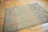 Aqua and subtle tan Khotan border pattern, showcasing low pile and gentle abrashes.