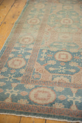 Aqua sea foam green Khotan rug's low pile with coral and cream motifs.