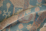 Folded detail of New Egyptian Khotan rug, highlighting low pile, aqua and rose hues.