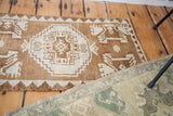 Vintage Oushak rug detail showing reciprocating geometric patterns in bronze and cream.