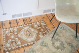 Soft bronze, grey, and rose medallion with reciprocating border on a vintage Oushak rug.