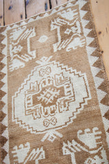 Bronze and cream geometric medallion and reciprocating border on vintage Oushak rug.