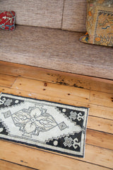 Geometric black and ivory patterns on this vintage Oushak rug's lower corner.
