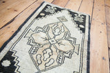 Textured central geometric design in black, ivory, and beige of a vintage Oushak.