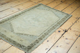 Soft beige gold field with subtle center medallion and charcoal bronze border.
