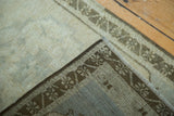 Vintage Oushak rug corner revealing soft beige pile and intricate dark bronze border weave.