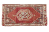 Vintage distressed Anatolian runner with bold red field, central medallion, and grey spandrels.