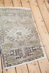 Oushak rug corner with white fringe and textured moss bronze geometric pattern.
