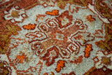 Textured pile of vintage Oushak rug, featuring tomato orange, grey, and ivory motifs.