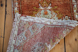 Vintage Oushak rug runner showing hand-knotted reverse, textural pile, and ivory fringe.