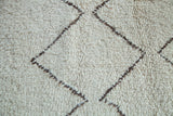 Close-up of shaggy ivory and silver brown zig zag pattern on vintage Moroccan carpet.