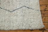 Textured ivory Beni Ourain rug pile with a geometric silver grey zigzag design.