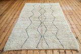 Vintage Beni Ourain carpet's shaggy ivory pile and silver grey zig zag diamond lines.