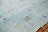 Super pretty blue vintage kilim rug, highlighting the embossed art silk motifs and decorative scalloped edge.