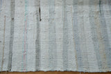 Hand woven rag rug texture with ivory, charcoal, and soft pastel stripes.