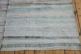 Textured hand woven vintage rag rug showing ivory, charcoal, and pastel striped pattern.