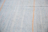 Woven detail of mid-century rag rug: ivory, pastel flecks, and prominent orange stripe.