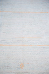 Hand-woven vintage rag rug detail: pastel ivory, blue, and peach stripes with motif.
