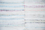 Hand woven vintage rag rug texture with central seam and pastel, neutral stripes.