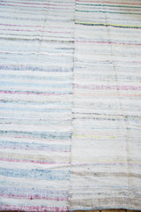 Hand woven vintage rag rug texture with pastel and neutral recycled linen strips.