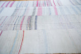 Textured hand woven vintage rag rug with pastel, ivory, ruby red, and charcoal stripes.