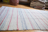 Hand-woven vintage rag rug with recycled linen texture, ivory, muted red, and charcoal stripes.