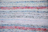 Close-up of hand-woven recycled linen rag rug, showing pastel pink, blue, ivory texture.