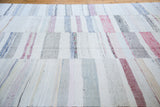 Hand woven vintage rag rug with pastel and neutral striped linen texture.