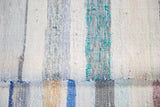 Hand woven recycled linen rag rug texture with pastel blue, ivory, and charcoal stripes.