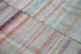 Detail of vintage hand woven rag rug, showing striped linen patchwork in pastels and neutrals.