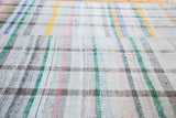 Plaid pattern with pastel and neutral stripes on the hand-woven vintage rag rug.
