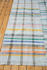 Unique plaid pattern on a vintage hand-woven rag rug in pastel and neutral colors.